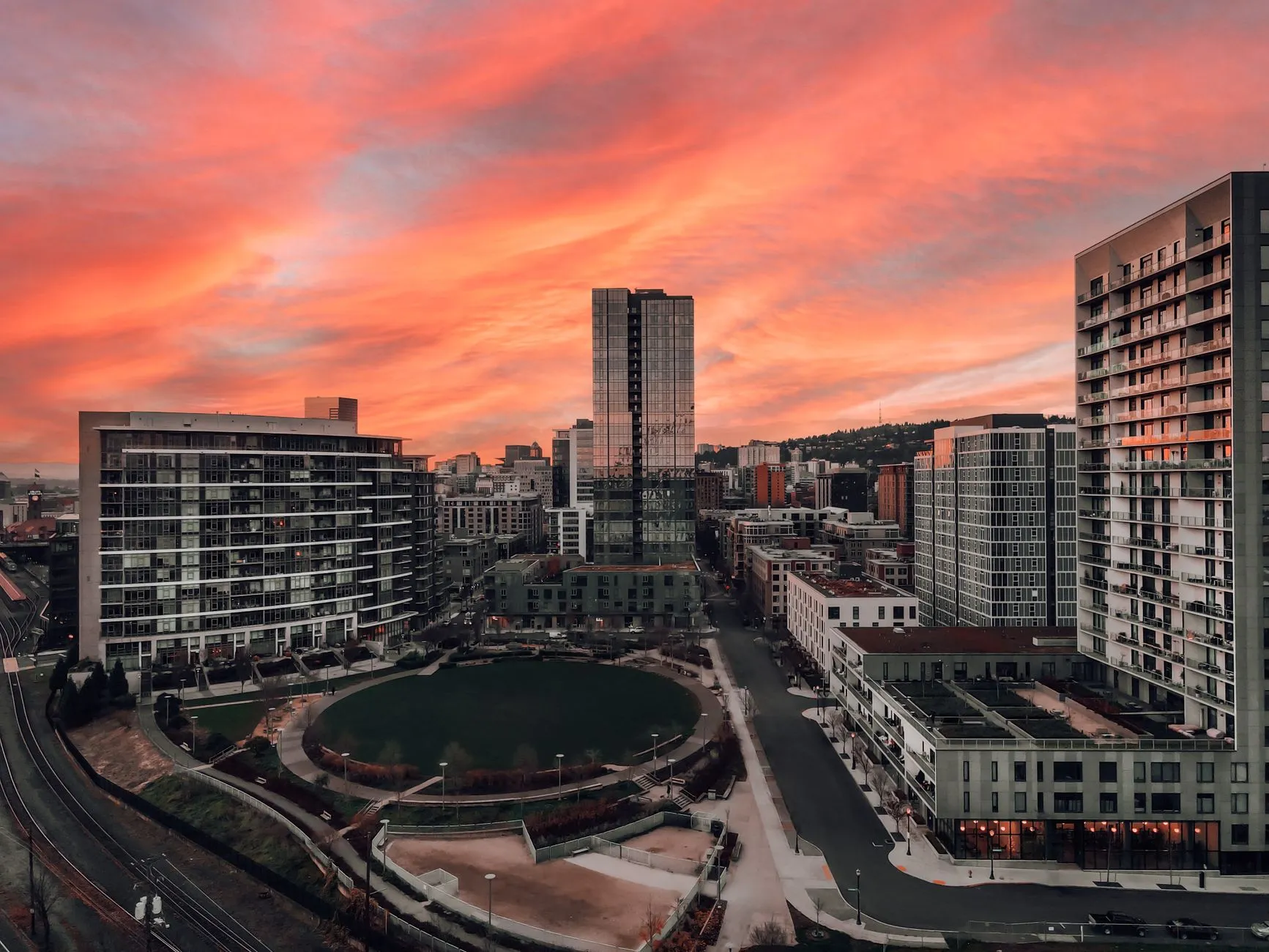 A city skyline glowing at sunset, seen from above