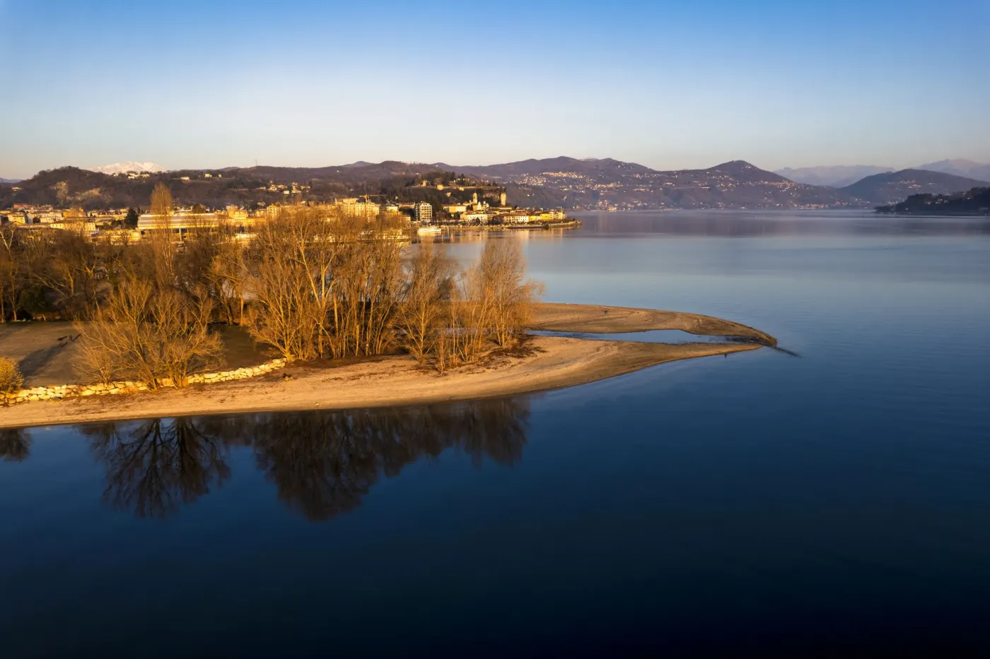 A lakeshore catching the last warm light from above